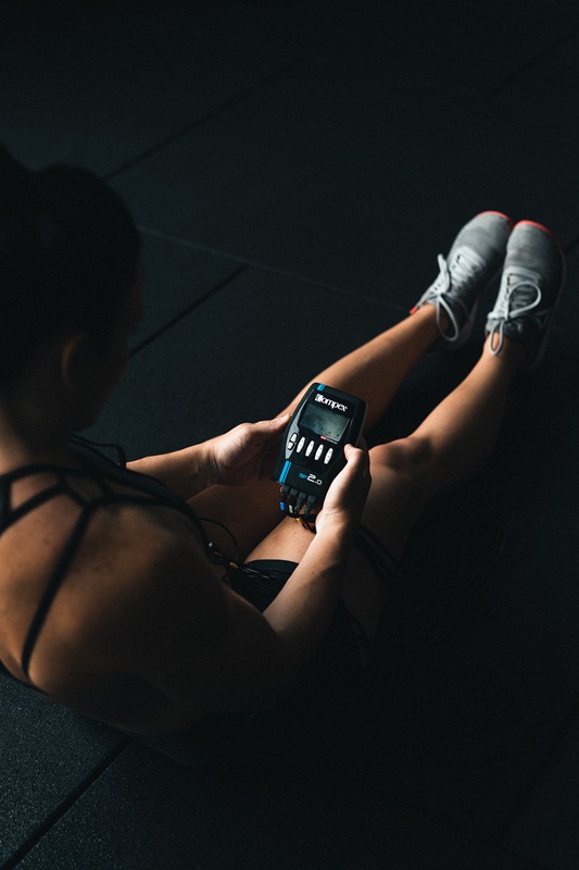 Compex elektrostimulator SP 2.0 in ženska v športni opremi